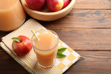 Tasty apple juice and fresh fruits on wooden table. Space for text
