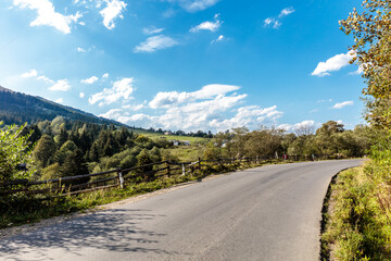 Fototapeta premium A road with a fence on the side and trees in the background