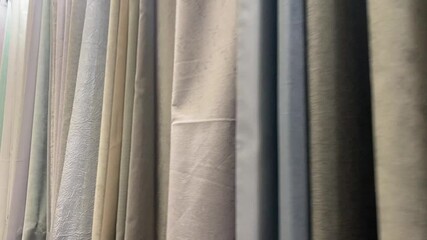 A curated collection of fabric drapery samples is displayed, showcasing vibrant colors and rich textures under soft lighting, offering perfect interior design inspiration