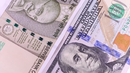 Close up view of rotating 500 Indian rupees and 100 USD american dollars, brand new notes. Selective focus. Money background.