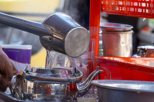 Man pours boiling water over a cloth filter containing ground coffee at a cafe in Phnom Penh