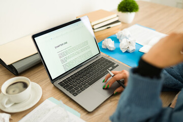Female writer working on novel, typing manuscript at home office desk, enjoying coffee while pausing from creative process