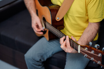 Guitarist on acoustic guitar playing melody in studio. Close up musician instrument