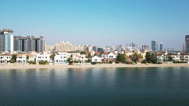 A drone flies in front of the facade of a luxury private villa with a swimming pool in Dubai