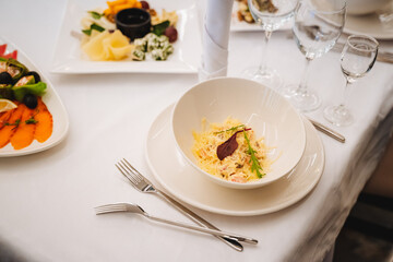 There is a table that is adorned with various plates filled with an assortment of delicious food items and utensils carefully arranged on it, ready for a delightful dining experience