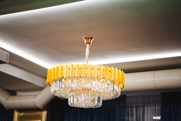 A large, beautifully designed chandelier is elegantly hanging from the ceiling of the room, adding an exquisite touch to the interior decor and creating a warm ambiance with its light