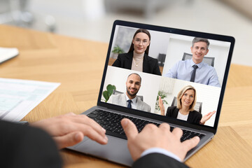 Business meeting. Man using laptop during online video chat at table, closeup