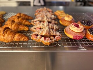 Strawberry croissant varieties on wire rack at bakery kitchen