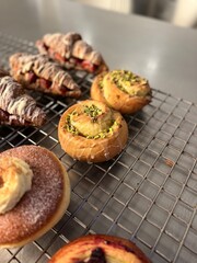 Pistachio bun roll on wire rack at bakery showcase