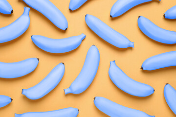 Obraz premium Light blue bananas on pale orange background, flat lay