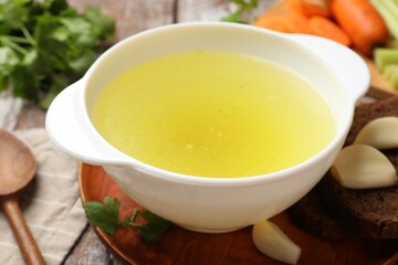 Tasty chicken bouillon served on wooden table, closeup