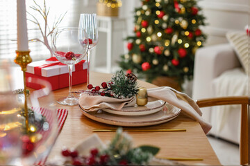 Christmas place setting with festive decor on wooden table in room