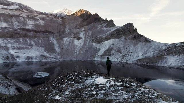 Fascinated explorer at the Ib&oacute;n de Sabocos in Panticosa, a spectacular frozen lake in the Tena Valley, Pyrenees of Aragon, captured from the sky with a drone showing unique snowy landscapes