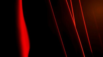 Close-up view of deep red fabric drapes or curtains, showcasing dramatic folds and curves against a rich black backdrop