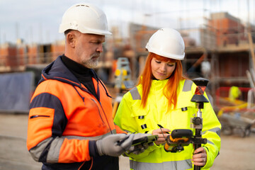 Construction workers collaborating on site with equipment in a busy urban environment