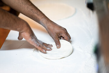 Cook hands kneading dough, piece of dough with white flour. close up on hands