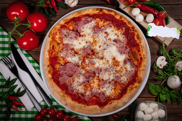 Pizza with prosciutto parma ham on wooden background top view. Italian cuisine