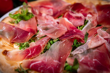 White pizza with prosciutto crudo, arugula and parmesan
