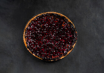 Shortbread tart with berries and fruits on a dark background close-up