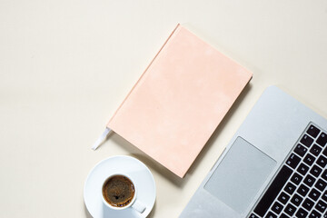 bright feminine banner or header with a coffee, stylish workspace with laptop computer, modern office accessories and a small notebook on a blush table, top view, flat lay