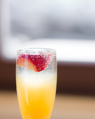 Cocktail Orange with sparkling wine and strawberries close-up