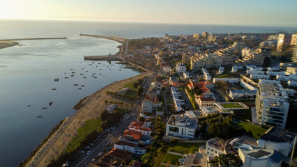 Fototapeta premium Vista capturando a deslumbrante paisagem do Porto e de Matosinhos, onde o Rio Douro encontra o Oceano Atlântico. A cena apresenta as areias douradas da praia de Matosinhos, 