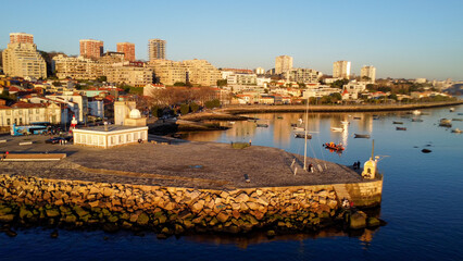 Fototapeta premium Vista capturando a deslumbrante paisagem do Porto e de Matosinhos, onde o Rio Douro encontra o Oceano Atlântico. A cena apresenta as areias douradas da praia de Matosinhos, 