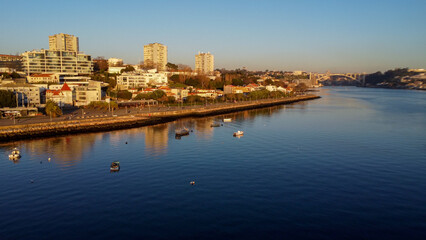 Vista capturando a deslumbrante paisagem do Porto e de Matosinhos, onde o Rio Douro encontra o Oceano Atlântico. A cena apresenta as areias douradas da praia de Matosinhos, 