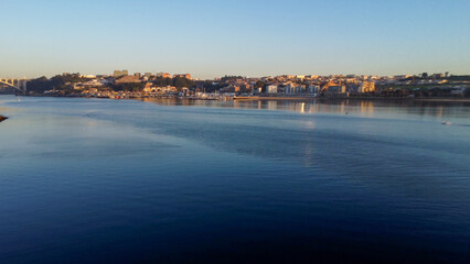 Vista capturando a deslumbrante paisagem do Porto e de Matosinhos, onde o Rio Douro encontra o Oceano Atlântico. A cena apresenta as areias douradas da praia de Matosinhos, 
