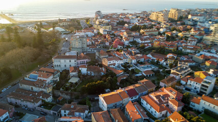 Vista capturando a deslumbrante paisagem do Porto e de Matosinhos, onde o Rio Douro encontra o Oceano Atlântico. A cena apresenta as areias douradas da praia de Matosinhos, 