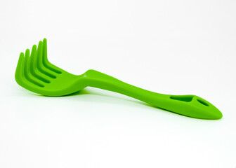 small plastic green rake for gardening and plant care at home, isolate, white background