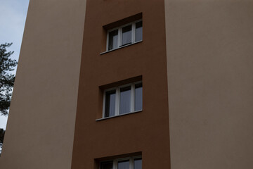 This is an exterior view of a modern residential building that prominently features multiple windows