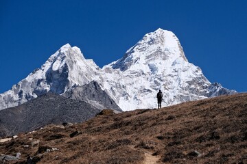 Amazing scenery of trekking to Ama Dablam Base Camp from Dingboche with little silhouette of standing trekker. Himalayas, Sagarmatha National Park, Nepal