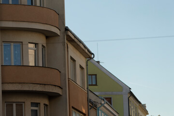 An urban scene showcasing distinct architectural elements of various buildings set against a clear, blue sky backdrop