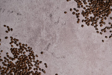 Top view roasted coffee beans in the two corners on gray concrete. Copy space background, cover,...