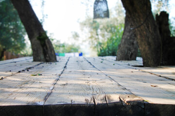 Blurred sunny background of summer garden through wooden rustic table.