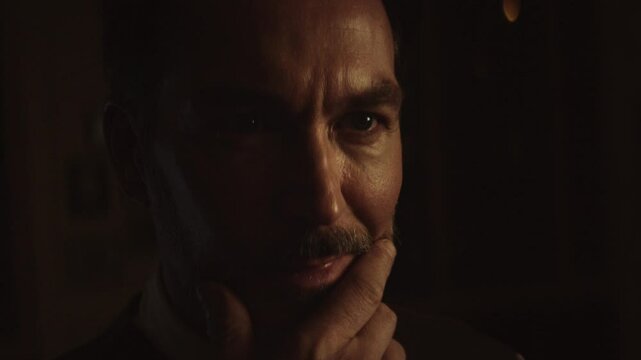 Thoughtful writer, illuminated by soft light, contemplates his next sentence, his expression shifting between deep thought and fleeting moments of inspiration