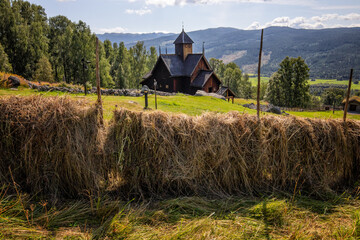 die stabkirche von uvdal mit heu im vordergrund