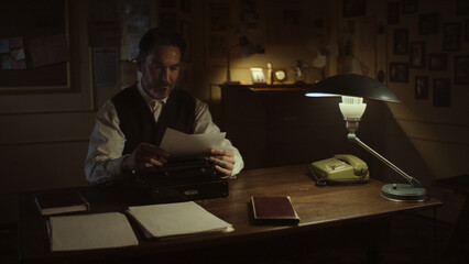 Writer working on typewriter in his office at