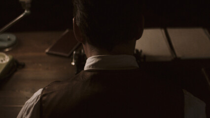 Writer working on typewriter in dimly lit room