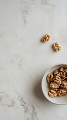 Walnuts in bowl on marble surface.