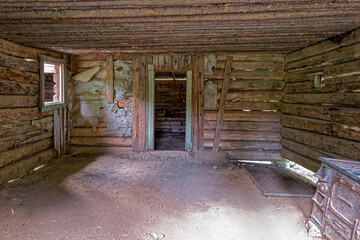 Light streams into the interior of an abandoned log cabin