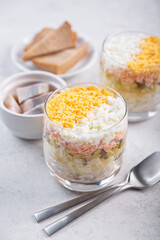 Herring layered salad with potatoes and eggs in a glass