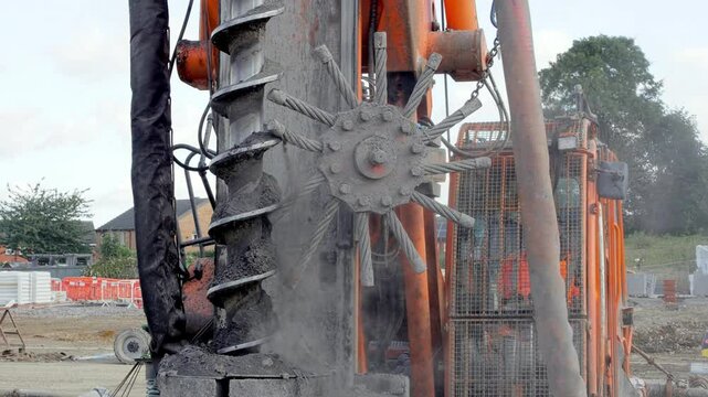 Heavy machinery Piling rig auger drills deep into ground at construction site in urban area