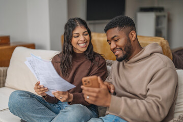 Couple enjoys a cozy afternoon together while reviewing documents and sharing moments on their smartphone
