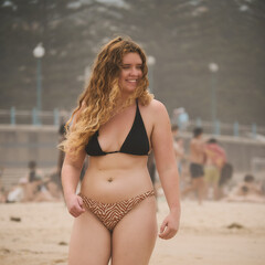 Smiling Woman in a Bikini Walking on the Beach