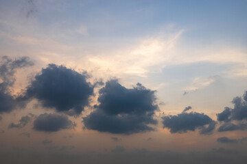 A serene sky during twilight, presenting a dramatic play of clouds and colors. Colorful cloudy sunset sky over tranquil sea surface