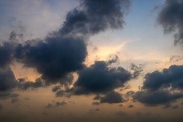 A serene sky during twilight, presenting a dramatic play of clouds and colors. Colorful cloudy sunset sky over tranquil sea surface