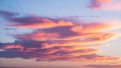 Fototapeta premium A breathtaking sunset with vibrant pink and orange clouds against a deep blue sky, creating a serene and tranquil atmosphere.
