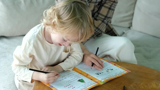 close-up mom helps her son do his schoolwork at home